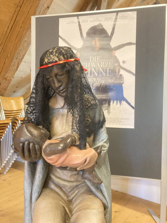 Die Statue der "Schwarzen Madonna" vor dem Filmplakat Die Statue der "Schwarzen Madonna" vor dem Filmplakat