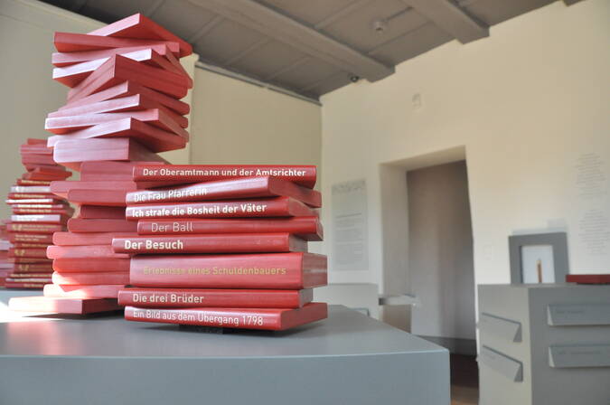 Biografieraum mit symbolischen Bücherstapeln Biografieraum mit symbolischen Bücherstapeln